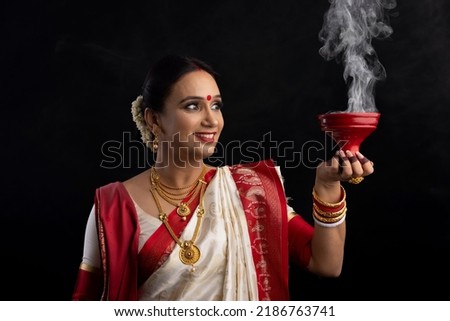 Portrait of Bengali woman holding a dhunuchi Royalty-Free Stock Photo #2186763741
