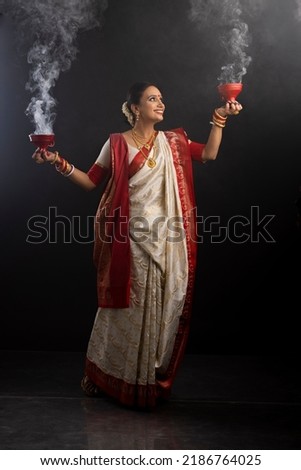 Portrait of Bengali woman holding a dhunuchi Royalty-Free Stock Photo #2186764025