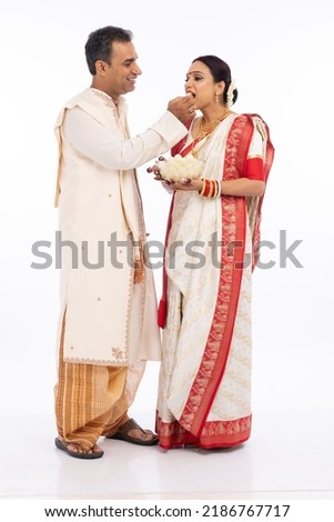 Bengali man feeding a rasgulla to his wife Royalty-Free Stock Photo #2186767717