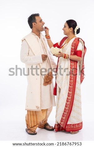 Bengali woman feeding a rasgulla to a man Royalty-Free Stock Photo #2186767953