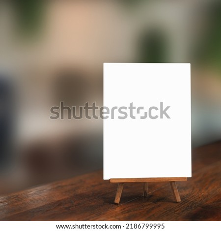 White paper counter menu on blurred restaurant background.