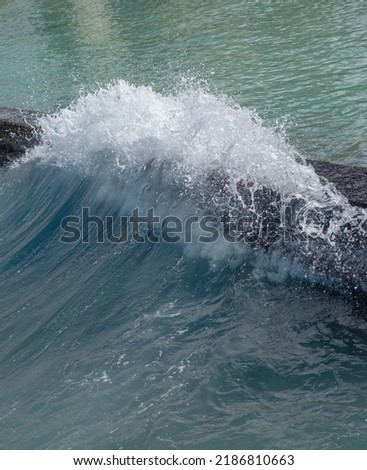 Breaking Ocean Wave on an Old Break Wall in Sunlight. Royalty-Free Stock Photo #2186810663