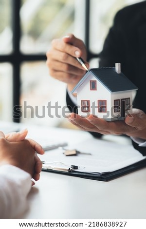 Rental company employee is discussing the details before the customer agrees to sign a rental contract, explaining the details and the terms and conditions of the rental. Real estate rental ideas.