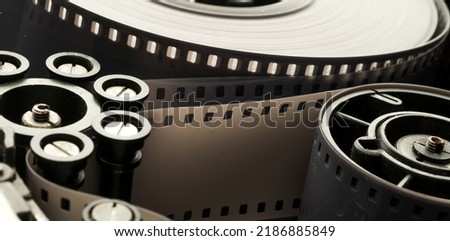 a roll of film in a film camera cassette. negative film in the tape drive mechanism of the cassette. show business film production technology concept Royalty-Free Stock Photo #2186885849