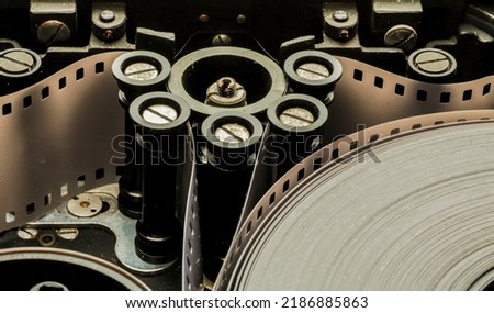 a roll of film in a film camera cassette. negative film in the tape drive mechanism of the cassette. show business film production technology concept