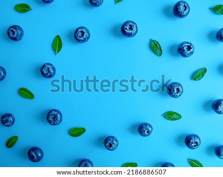 Creative summer round frame made of blueberries on bright blue background. Original blueberry decoration. Minimal summer concept. Welcome summer. Copy space.