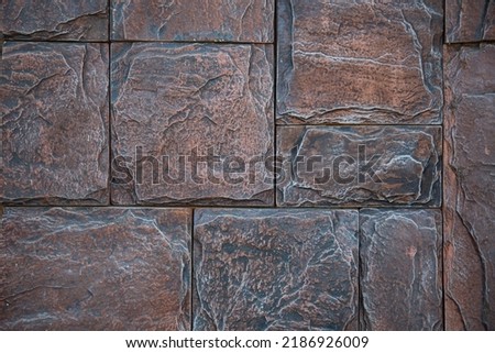 Texture background of the house facade. Brickwork. Luxurious stone fence. Exterior and interior. Building design. Tile coating. Multicolored asymmetrical stones.