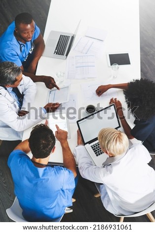 Doctors, medical professionals or healthcare workers with laptop talking, meeting or planning hospital medicine treatment. Above view of diverse group of physician colleagues brainstorming with tech