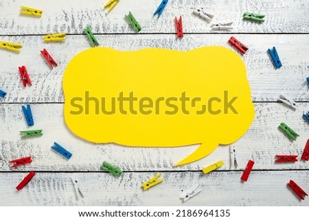 Colorful Pegs Placed Around Speech Bubble With Important Information. Wooden Clips Arranged All Over Dialogue Ballon With Crutial Idea. Pins With Critical Data Inside.