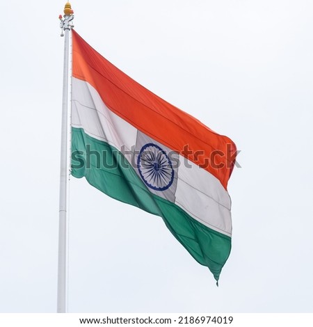 India flag flying high at Connaught Place with pride in blue sky, India flag fluttering, Indian Flag on Independence Day and Republic Day of India, tilt up shot, Waving Indian flag, Har Ghar Tiranga Royalty-Free Stock Photo #2186974019