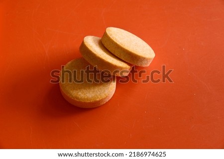 close-up of three vitamins pills isolated on orange background