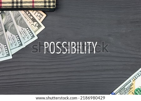 POSSIBILITY - word (text) on a dark wooden background, dollars, banknotes and a wallet. Business concept (copy space).
