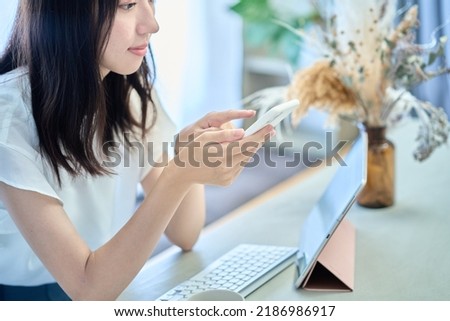 A woman operating a smartphone Royalty-Free Stock Photo #2186986917