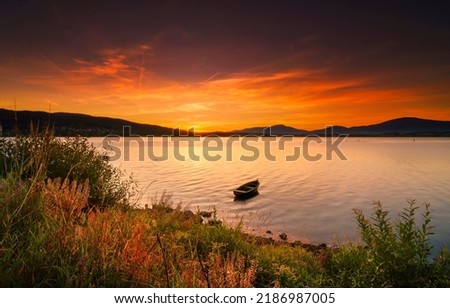 Boat in the lake at sunset. Sunset lake boat. Lake boat at sunset. Boat in lake at sunset Royalty-Free Stock Photo #2186987005