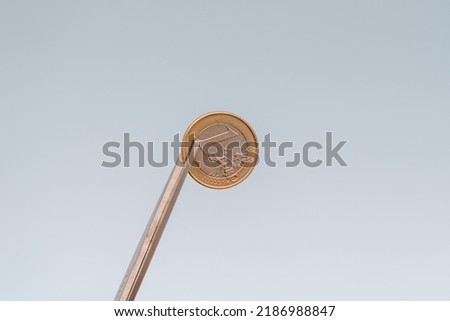Scissors cuts coin (euro) on blue background