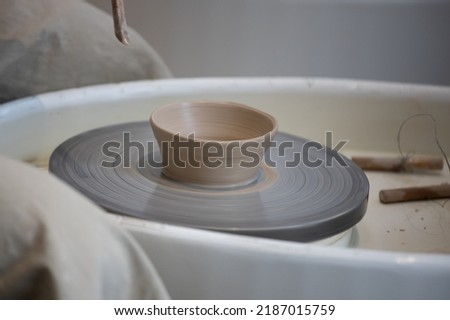 close-up of a potter's wheel and tools. Cup and tools on pottery wheel