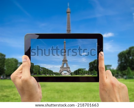 close up of hand photographing with a tablet the Eiffel tower in Paris France