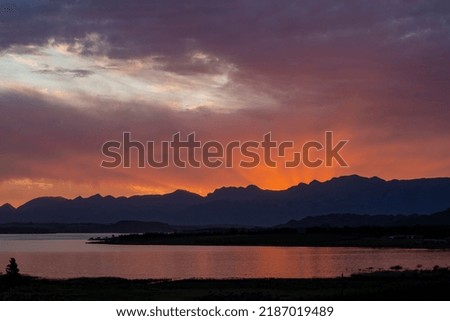 A beautiful shot of the evening orange sun setting behind a mountain
