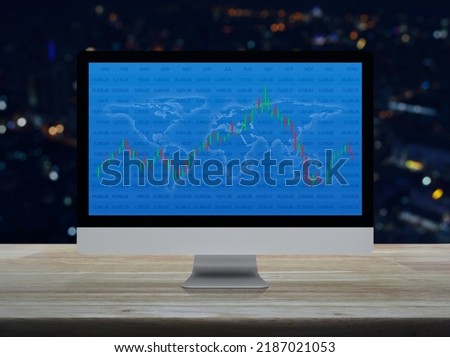 Trading graph of stock market with world map and graph on computer screen on wooden table over blur night light city tower, Business investment online concept, Elements of this image furnished by NASA