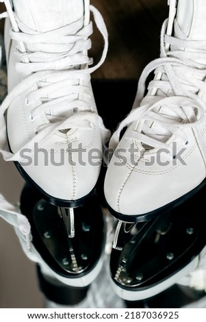 Female white ice skating boots with untied shoelaces
