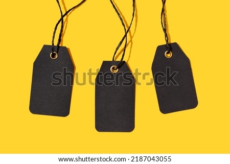 Group of three Blank black tags isolated on yellow background. Template Mock up