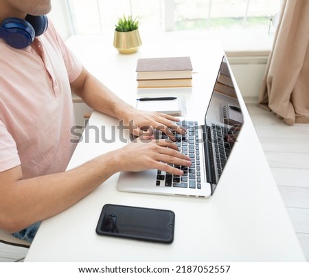 Close-up photo of man typing on keyboard of laptop. Work from home and online education concept