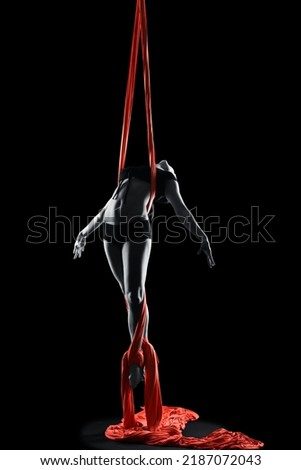 Young woman gymnast with red gymnastic aerial silks on black background