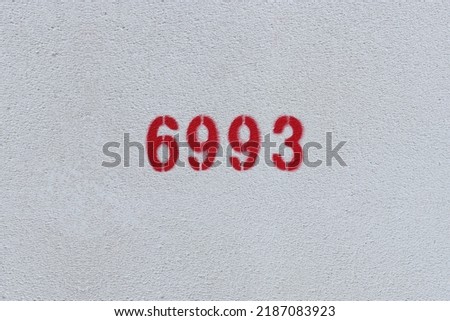 Red Number 6993 on the white wall. Spray paint.

