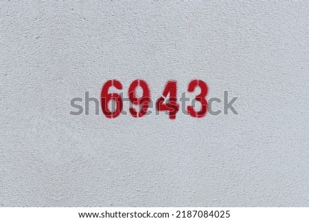 Red Number 6943 on the white wall. Spray paint.
