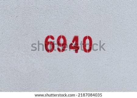 Red Number 6940 on the white wall. Spray paint.
