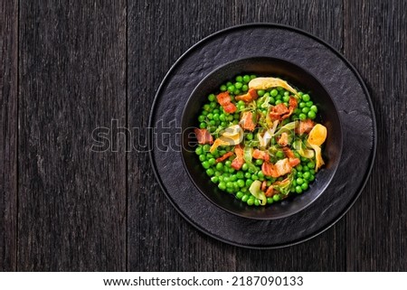petits pois, french dish of tender, new-season peas braised in chicken stock with lettuce, onion bulbs and speck, cut into lardons,  served in bowl, horizontal view from above, flat lay, free space