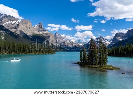 A boat cruise departs from Spirit Island on Maligne Lake in Jasper National Park on a sunny day Royalty-Free Stock Photo #2187090627