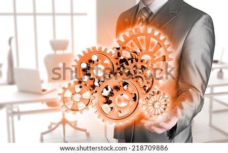 businessman hand touch blue gear to success as concept