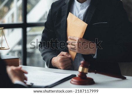 Individuals are giving bribes to officials in order to commit corruption in lawsuits, illegal actions by law enforcement by paying bribes to officials are illegal and unlawful. Fraud concept. Royalty-Free Stock Photo #2187117999