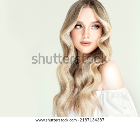 Beautiful girl with hair coloring in ultra blond. Stylish hairstyle curls done in a beauty salon. Fashion, cosmetics and makeup Royalty-Free Stock Photo #2187134387