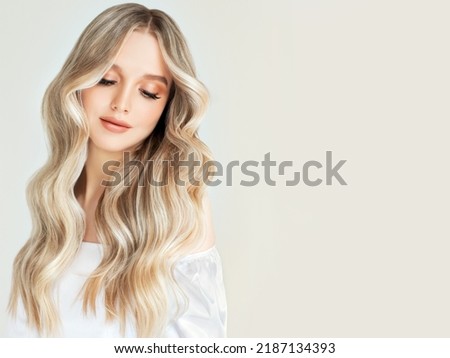 Beautiful girl with hair coloring in ultra blond. Stylish hairstyle curls done in a beauty salon. Fashion, cosmetics and makeup Royalty-Free Stock Photo #2187134393