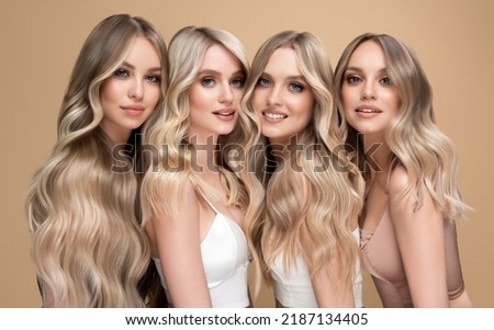 Four beautiful women    with hair coloring in ultra blond. Stylish hairstyle curls done in a beauty salon. Fashion girls , cosmetics and makeup. Royalty-Free Stock Photo #2187134405