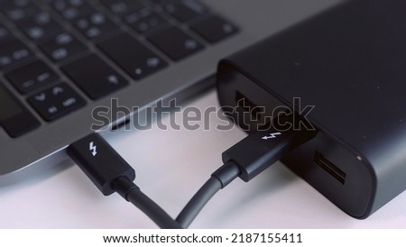 Close up of external hard drive connected to laptop. Action. Black hard disc for backup files and important information using USB 3.0 connection.