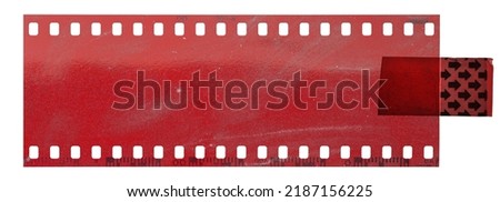 long red 35mm cine film strip fixed by sticker on white background.  Royalty-Free Stock Photo #2187156225