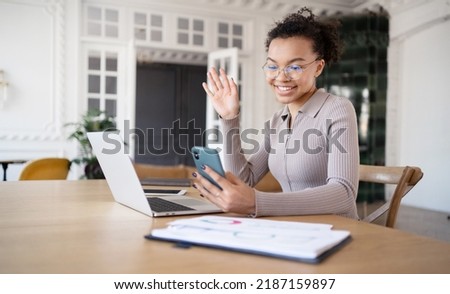 A woman in the office video communication chat online communication uses a laptop, answers the client's mail and phone