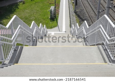 Stairway to footbridge or overpass divided into two sides for walking up and down, Stainless steel railing for people walk cross the road crossing safety. Royalty-Free Stock Photo #2187166541