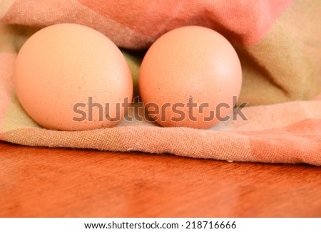 Two eggs on an plaid earth tone towel