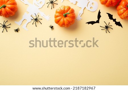 Halloween party concept. Top view photo of pumpkins spiders skeleton and bats silhouettes on isolated beige background with copyspace