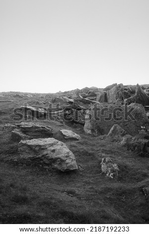 black and white monochrome View over rocks and grass on a grey rainy day on hillside in wales, UK