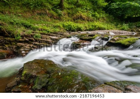 Long exposure of the Watersmeet Bridge waterfall on the East Lyn river at Watersmeet In Exmoor National Park