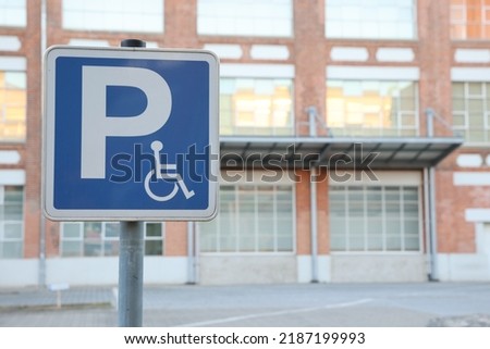 Parking slot for persons using wheelchair on the area in front of big retail building