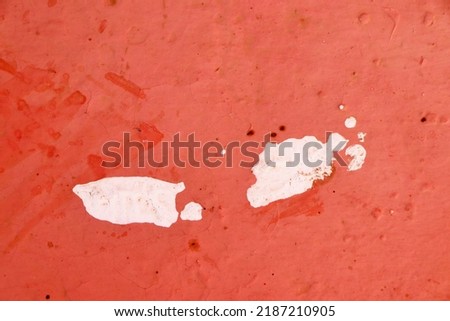 Abstract white paint grunge on red background. White paint stains on red rough wall. 
