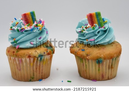 Delicious birthday cupcake with blue icing and rainbow candy
