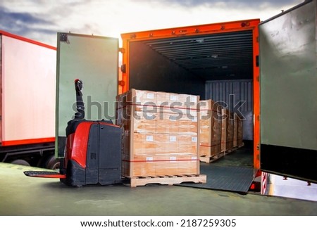Packaging Boxes Wrapped Plastic Stacked on Pallets Loading into Cargo Container. Electric Forklift Pallet Jack Loader. Supply Chain. Shipment. Supplies Warehouse. Freight Truck Transport Logistics. Royalty-Free Stock Photo #2187259305