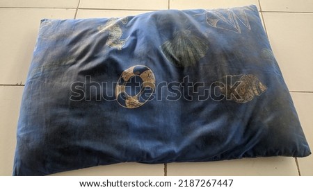 dirty and worn dark blue pillow that should have been thrown away